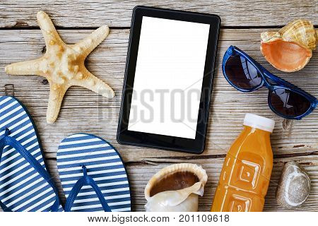 Beach background. Beach accessories, sea souvenirs and a tablet computer on a wooden background. Concept: beach vacation, vacation, travel.