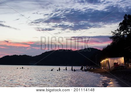 Waterfront cottage on the beach with twiligh sky.