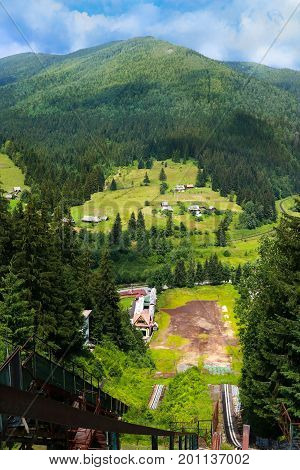 summer view of Carpathian Mountains landscapevillage Vorohta Ukraine. Green forests, hills, grassy meadows and blue sky. View from the ski jump