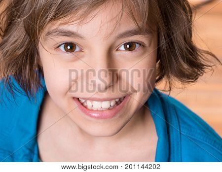 Emotional portrait of attractive caucasian little student girl with beautiful brown eyes. Funny cute smiling child looking at camera - close-up.