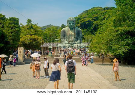 TOKYO, JAPAN JUNE 28 - 2017: Crowd of people posing and taking pictures at monumental bronze statue of the Great Buddha in Kamakura, Japan.