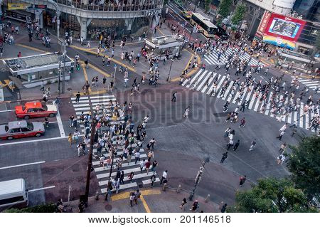 TOKYO, JAPAN JUNE 28 - 2017: Top view of crowd of people crossing in Shibuya street, one of the busiest crosswalks in the world, in the Ginza District in Tokyo, Japan.
