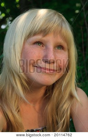 giovane ragazza con un sorriso in un legno verde
