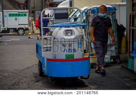 TOKYO, JAPAN JUNE 28 - 2017: Unidentified man walking near of a cargo machine in Fish Tsukiji Market is the biggest wholesale fish and seafood market in the world, in Tokyo.