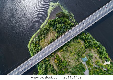 Aerial view of the bridge and the road over the Dnepr River over a green island in the middle of the river. Kiev, Ukraine