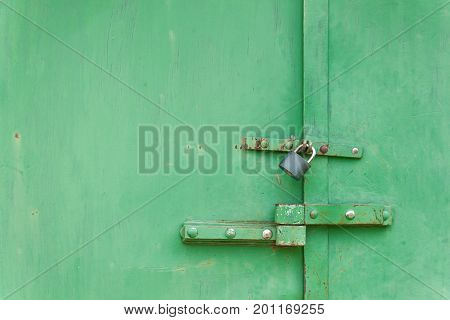 Old iron gate with lock. Locked sheet metal doors. Place for your text. Home security concept