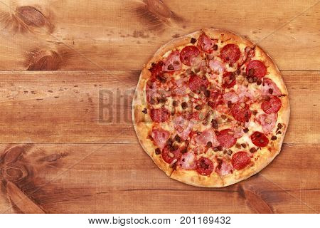 Pizza on wooden. Wooden table top view. On the table are the food for cooking. Healthy food. Dietetic foods. Above view on food. Hot Homemade Pepperoni Pizza Ready to Eat