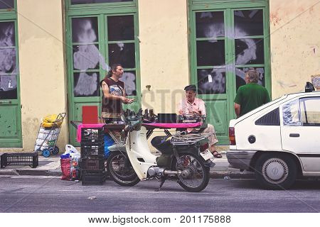 ATHENS, GREECE - JULY 16, 2017: Man bargains at flea market in Psiri area street, Monastiraki, Athens
