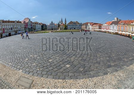TIMISOARA ROMANIA - AUGUST 24 2017: View of one part at Union Square in Timisoara Romania with old buildings. Trinity Statue and serbian vicariate in background.