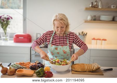 Senior woman preparing meal in kitchen