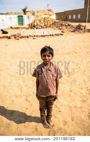 RAJASTHAN INDIA - MARCH 07 2016: Vertical picture of native indian boy posing in Thar Desert located close to Jaisalmer the Golden City in India.