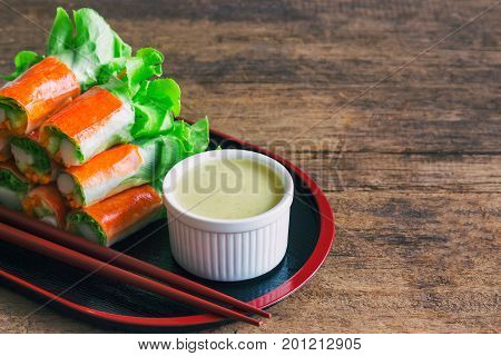Fresh spring rolls with fresh vegetable and crab stick served with wasabi mixed salad cream dipping sauce. Rolls salad or fresh spring roll in Japanese style healthy tasty food for appetizer or meal.  Fresh spring rolls in fusion food style