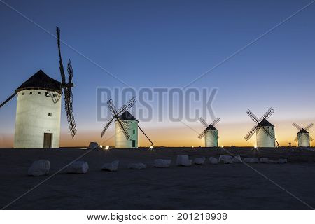 Illuminated traditional windmills at rising Campo de Criptana Spain