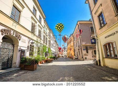 Lublin, Poland - August 10, 2017: Beautiful street and old bright buildings in the old town of Lublin, Poland. Center of Lublin, Brama street. Mountebanks Carnaval in Lublin old town.