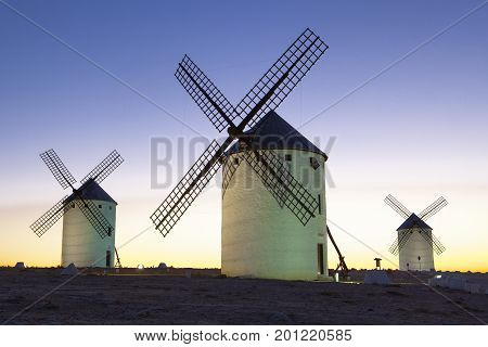 Illuminated traditional windmills at rising Campo de Criptana Spain