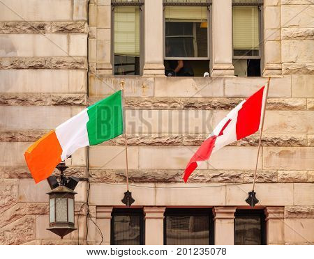 Irish and Canadian flags on an old stone building in Victoria British Columbia