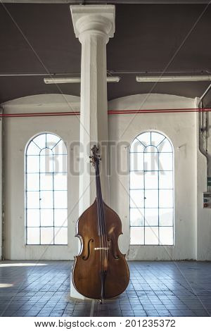 A cello laying on a column in an industrial vintage location