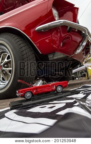 ZAMOSC POLAND - August 13 2017: Classic retro Ford Mustang GT with miniature version.Car exterior details. Headlight of a retro car.