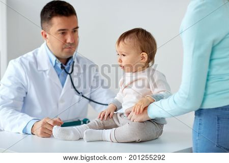 medicine, healthcare, pediatry and people concept - happy woman with baby and doctor at clinic