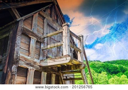 Idyllic Alpine shelter or chalet in summer on a mountain meadow during thunderstorm.