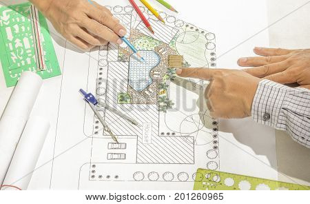 Landscape architect changing drawing at meeting with client