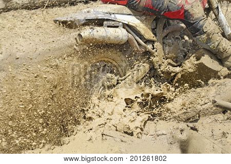 Motocross accelerating speed in mud trace .