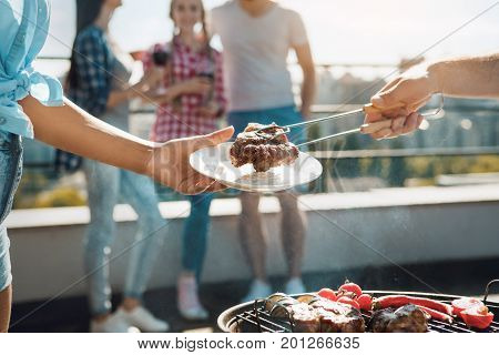 Group of people having barbecue party cooking meat