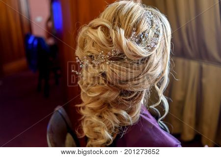 Beautiful bride fashion wedding hairstyle with jewelry back view. Blond girl with curly hair styling. Hairstyle for long hair with stylish hair accessory