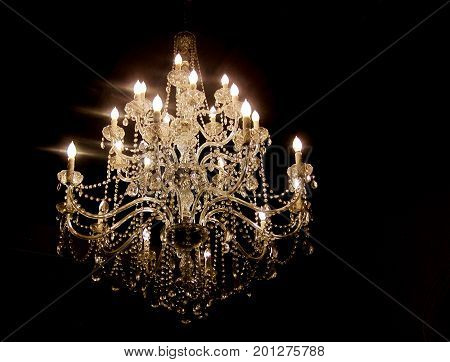 Dark room with older hanging lit chandelier