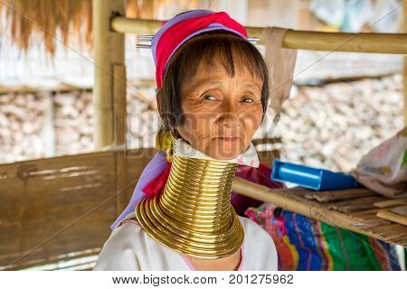 CHIANG MAI, THAILAND - July 10, 2017: Karen hill-tribe (Long Neck) woman weaving fabrics for a living at her house.