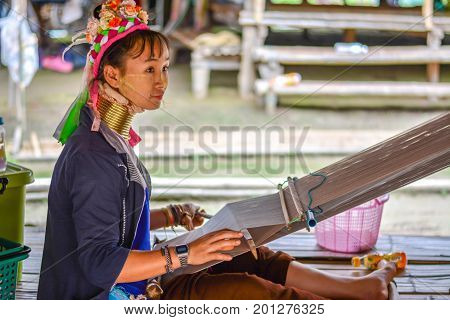 CHIANG MAI, THAILAND - July 10, 2017: Karen hill-tribe (Long Neck) woman weaving fabrics for a living at her house.
