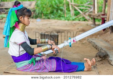 CHIANG MAI, THAILAND - July 10, 2017: Karen hill-tribe (Long Neck) woman weaving fabrics for a living at her house.
