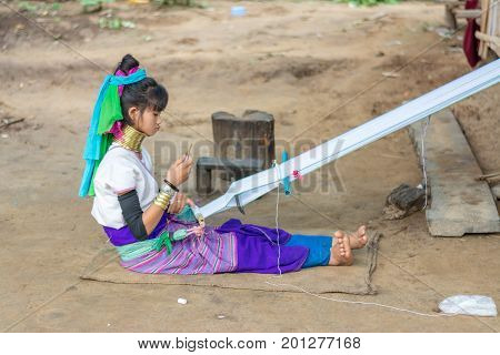CHIANG MAI, THAILAND - July 10, 2017: Karen hill-tribe (Long Neck) woman weaving fabrics for a living at her house.