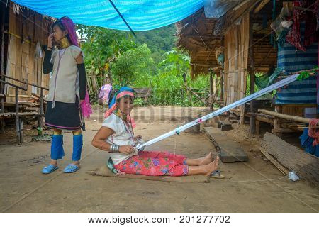 CHIANG MAI, THAILAND - July 10, 2017: Karen hill-tribe (Long Neck) woman weaving fabrics for a living at her house.