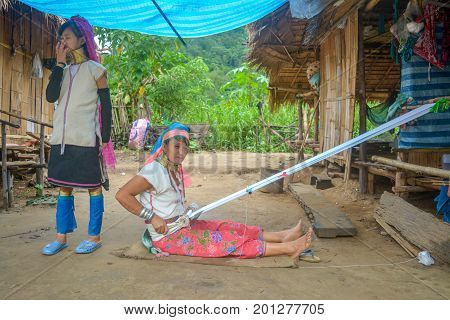 CHIANG MAI, THAILAND - July 10, 2017: Karen hill-tribe (Long Neck) woman weaving fabrics for a living at her house.