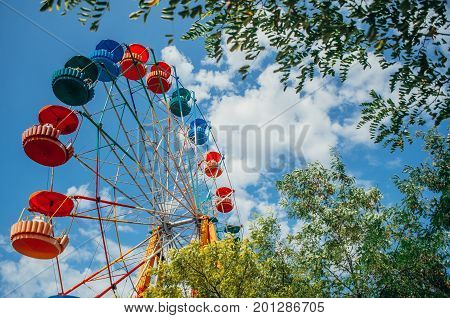 Brightly Colored Ferris Wheel Against The Blue Sky