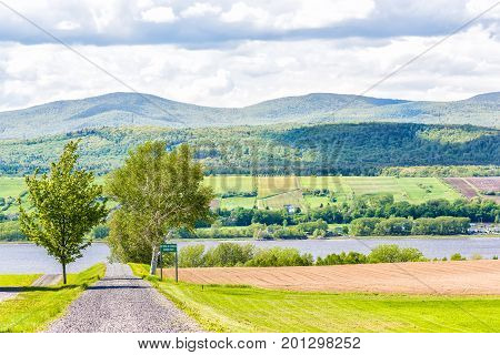 Ile D'Orleans Canada - June 1 2017: Landscape with plowed field in summer and trail path road with private sign
