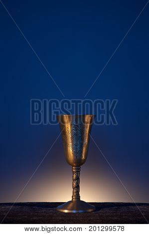 Vintage copper goblet for wine on wooden and bluebackground
