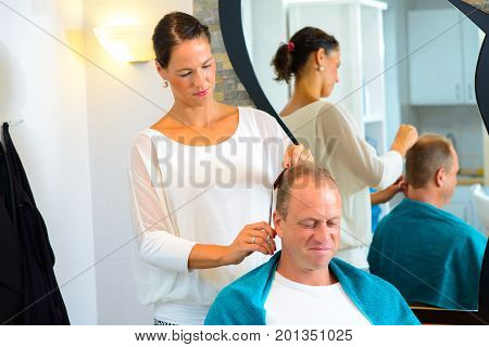 Female Hairdresser Cutting Hair Of Man