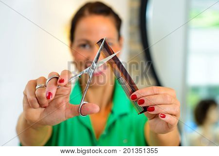 Female Hairdresser Cutting Hair Of Man
