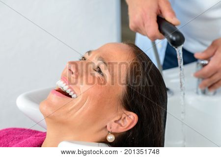 Hairdresser Washing Hair Of Woman