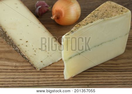 Traditional swiss cheese with garlic and onion on wooden table