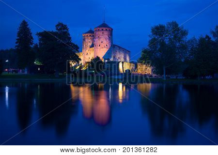 A view of the medieval Olavinlinna fortress of the blue August night. Savonlinna, Finland