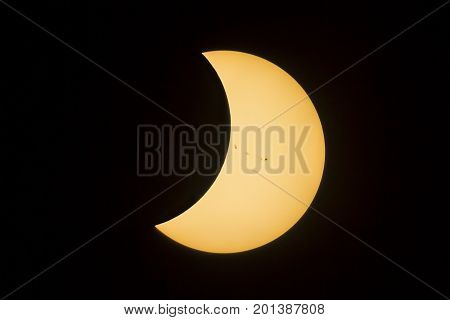 The sun with a prominent group of sunspots emerges from behind the moon during the total solar eclipse in August 2017.