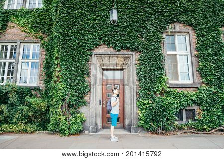 man listening music building in ivy on background summer day