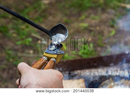 Traditional manual metal casting process to form aluminum tin press bullets old musket