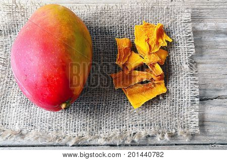 Raw organic dried mango and fresh ripe mango fruit on wooden rustic table.Dried mangos.Selective focus.