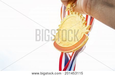 Winner hand holding golden medals to blur building background for show team success with their business Champion and Awards Concept
