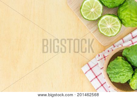 Close up fresh bergamot and bergamot slice in wooden bowl on dark wood table background. bergamot on old wooden brown with copy space. (Bergamot or Kaffir lime)