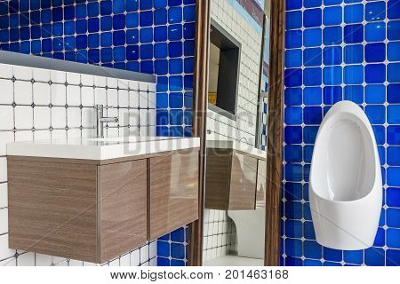 Interior of bathroom with toilet mirror and chrome faucet in the wash basin cabinet in the on wall.